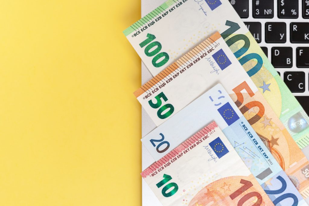 Different Euro Bills On A Laptop Background And On A Yellow Background